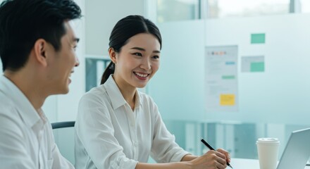 Smiling Korean professionals discussing ideas in modern office