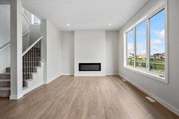 Obraz premium Large open living room with a fireplace and a window