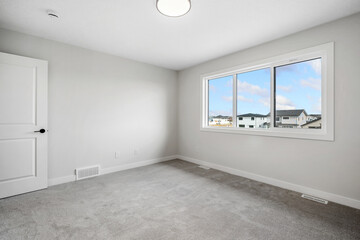 Large window in a white room with a view of the city