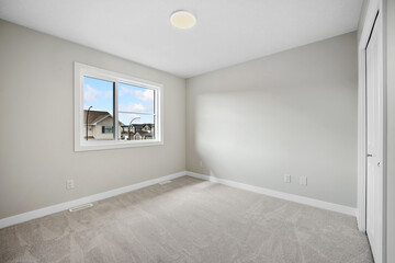 Very clean and empty bedroom with a large window