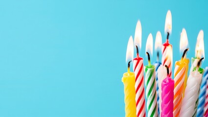 Colorful birthday candles burning brightly against a vibrant blue background