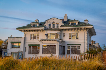 Old house by the coast in Seagate, Lower Bay, New York. An old house by the coast in Seagate. The building stands near sandy dunes.