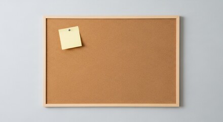 Blank Cork Bulletin Board with Yellow Sticky Note.