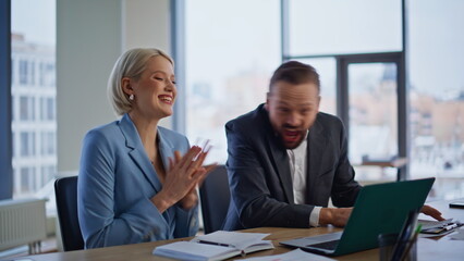 Obraz premium Excited partners rejoicing win looking laptop screen in light office closeup