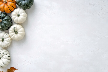 Assorted pumpkins arranged around empty space on white background, creating festive seasonal background