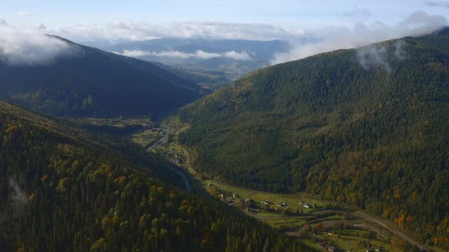 Breathtaking bird's eye view of the serene Prut River valley nestled between evergreen mountain slopes. Carpathian mountains, Ukraine.