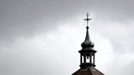 slender silhouette of church bell tower stands against cloudy steel sky evoking sense of calm
