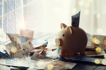 A piggy bank in the form of a pink pig stands on the wooden table with russians money, inscription...