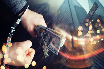  Double exposure city and hands of a man with handcuffs on a background of us dollars. Fraud, cyber...