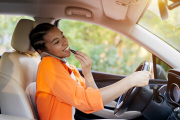 Happy young African American pregnant woman driving car, talking on phone, eating snack with smile. Concept of multitasking, lifestyle, and joyful maternity travel