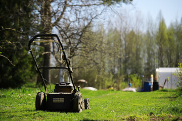 Lawnmower on a green meadow in spring