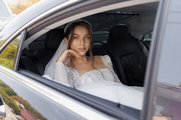 Bride in elegant gown waiting in a car on a beautiful day before the wedding ceremony