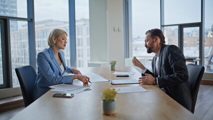 Annoyed accountants having disagreement resolving issues at panoramic office