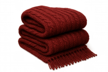 Cozy red knitted blanket, softly folded, featuring decorative tassels, draped against transparent backdrop