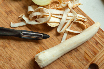 Peeled parsley root lies on a wooden board