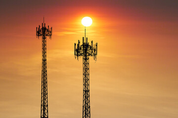 Telecommunication Towers at Sunset: The silhouettes of two imposing telecommunication towers, reaching towards the fiery sun in a vibrant sunset, symbolizing connectivity, innovation.