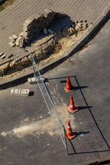 Three weathered orange construction cones placed diagonally on a grimy asphalt surface, a visual that works well for design concepts related to urban decay, road maintenance, or as a stylized backgrou