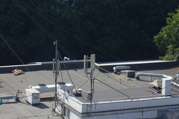 A close-up view of a mobile communication antenna installation on a flat roof, ideal for illustrating modern telecommunications technology, network infrastructure, or urban digital connectivity concep