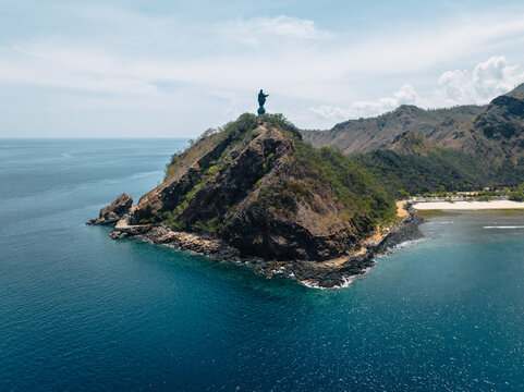 Aerial view of Cristo Rei of Dili perched atop a rocky headland, where the statue meets the sky above the azure sea, Dili, D&Atilde;&shy;li, Timor-Leste.