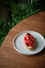 toast with cheese, cherry tomatoes, sun-dried plum. homemade bread. Side view. Wooden background