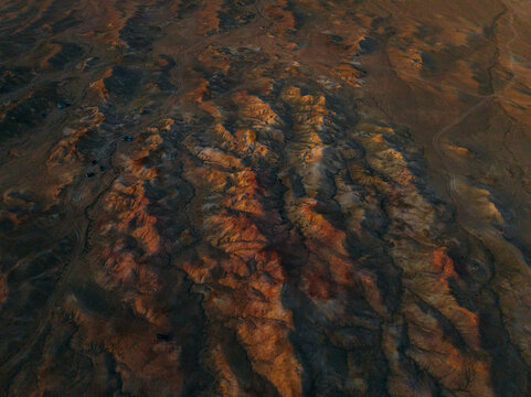 Aerial view of the rugged landscape of Tsagaan Suvarga, with its striking rock formations painted in hues of orange and brown by the setting sun, Tsagaan Suvarga, White Stupa, Mongolia.