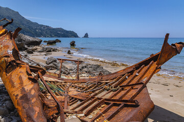 Rusty shipwreck in Agios Gordios holiday resort village on west coast of Corfu Island, Greece