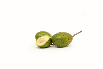 Two whole ambarella fruits (kedondong) and one cut in half to reveal its fibrous, spiny core. The green fruits are arranged on a clean, white background.