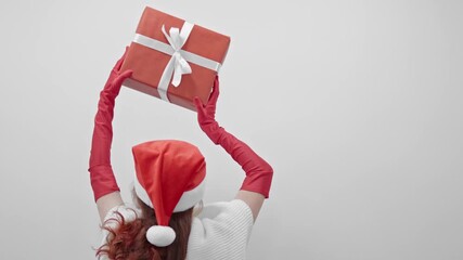A stylish individual, adorned with a festive Santa hat and vibrant red gloves, joyfully holds up a beautifully wrapped gift, perfectly capturing the joyful spirit of the cheerful holiday season - Powered by Adobe