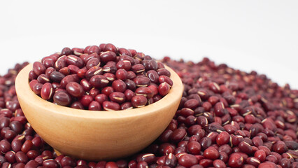 Raw Red Adzuki Beans in Wooden Bowl on Pile of Beans Background