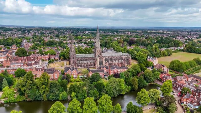 A rotating aerial view of the cathedral and the Minster Pool in the town of Lichfield, UK in summertime