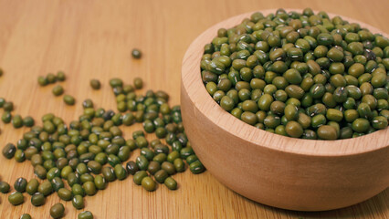 Mung beans in wooden bowl on wooden surfaceMung beans in wooden bowl on wooden surface