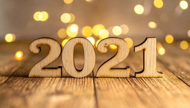 Wooden 2021 numerals on a rustic wood surface with bokeh