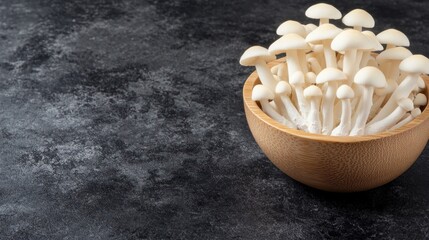 White beech mushrooms in wooden bowl on dark background