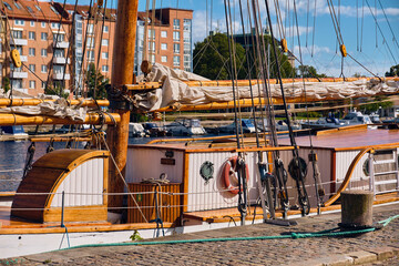 Mast, gaff rig boom with furled sails and guiding lines, and deck with cabins, on a sailing ship along the quay of Halmstad, Sweden