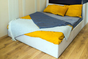 Modern made up bed inside bedroom interior