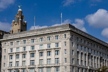 Obraz premium Stone Building with Tower and Flags in Liverpool, UK.