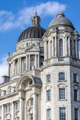 Obraz premium Two Domes on Classical Building Against Blue Sky in Liverpool, UK.
