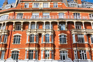 Ornate brick building with windows and balconies  in London, UK.
