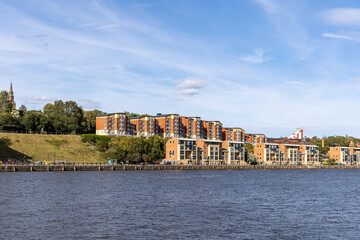Waterfront apartments and church spire with blue sky  in Newcastle upon Tyne, UK.