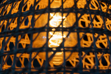 Warm glowing light through woven cage