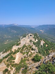 Fototapeta premium Château en ruine sur une colline boisée et ensoleillée