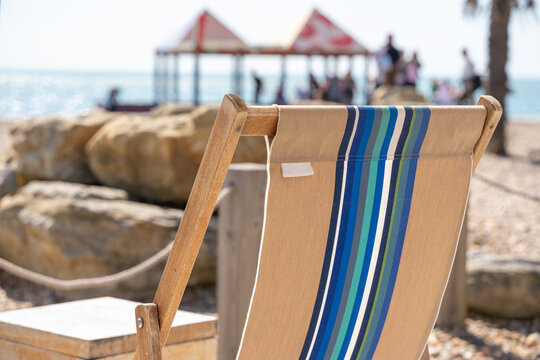 Beach scene with deck chair and distant pier