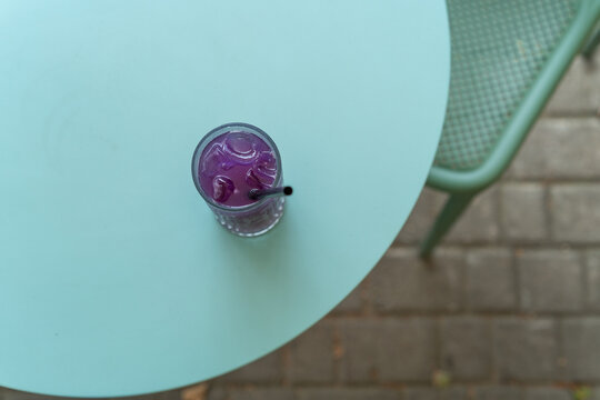 Overhead view of a refreshing iced blue matcha tonic drink on a garden table in the summer