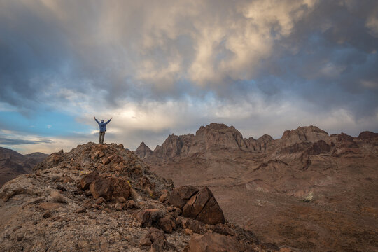 Rear view of a Hiker standing on a mountain with his arms outstretched, Turtle Mountains wilderness, California, USA