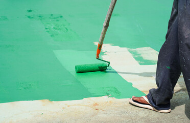 Man painted flooring with paint rollers for waterproof, reinforcing net, Repairing waterproofing deck flooring. Roof.