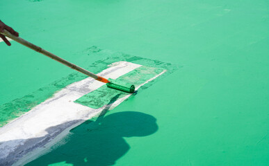 Man painted flooring with paint rollers for waterproof, reinforcing net, Repairing waterproofing deck flooring. Roof.