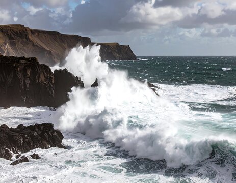 Powerful waves crash against dark cliffs