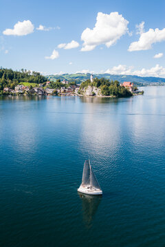 Boat sailing past Traunkirchen on a peninsula in Lake Traunsee, Salzkammergut, Upper Austria, Austria