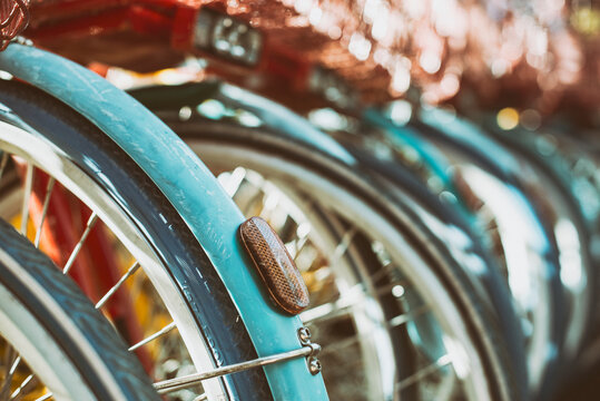 Close-up of the rear wheels and reflector lights of a row of bicycles parked side by side, Silicon Valley, California, USA