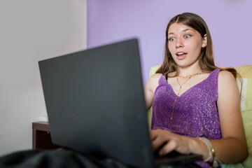Beautiful young girl working or communicating with her laptop